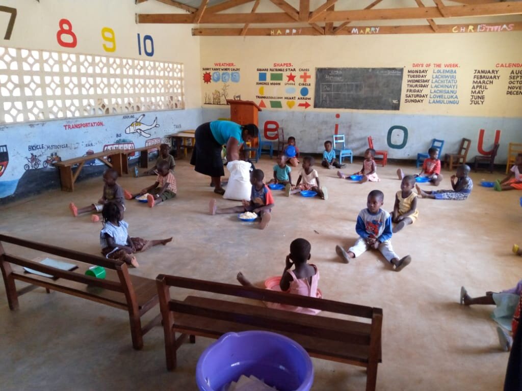 Children receiving 'take home' bags of likuni phala which is a fortified maize porridge.