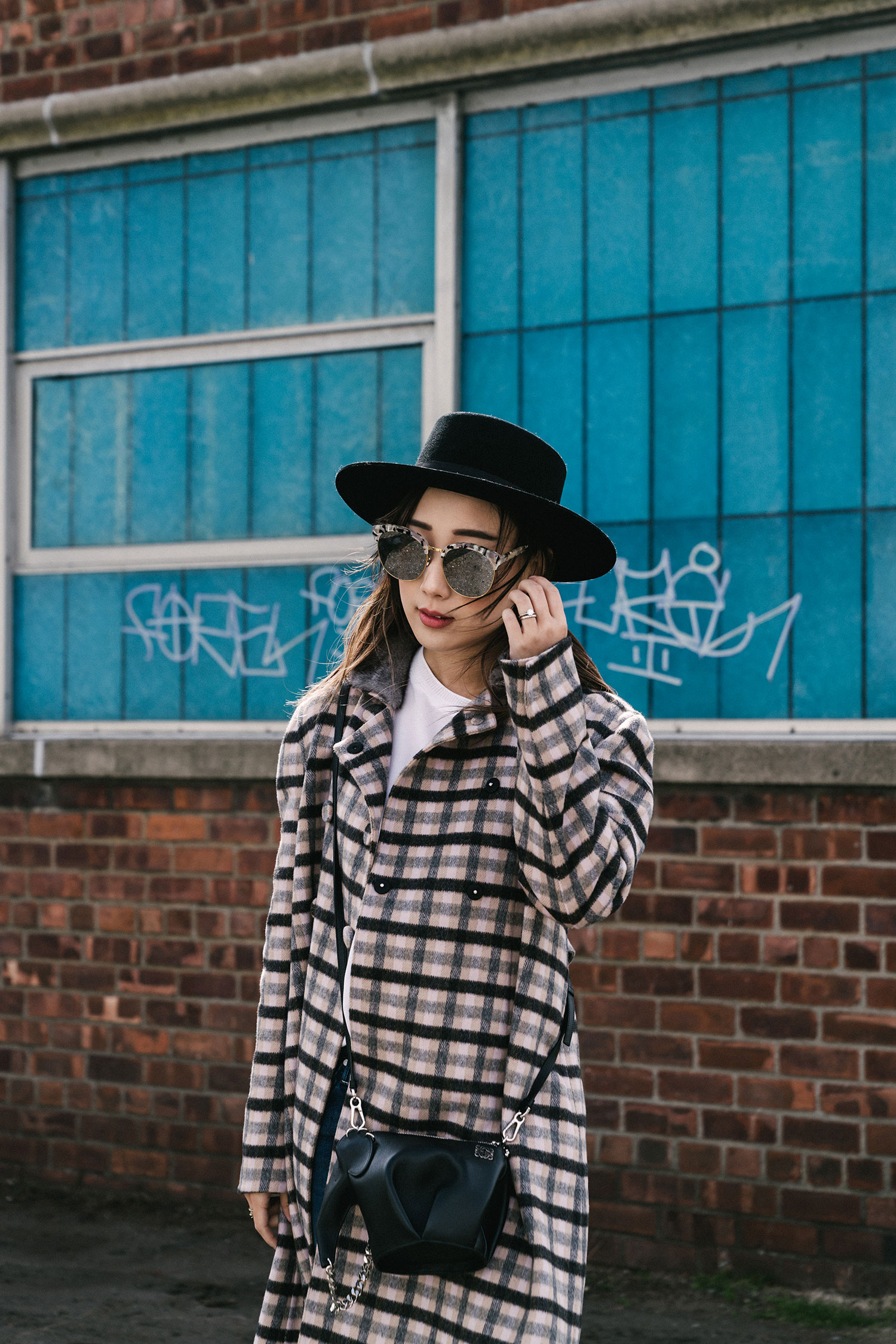 普拉达(Prada)大衣,文斯(Vince)上衣,牛仔布妈妈(Mother Denim),罗意威包(Loewe 袋),亲爱的弗朗西丝靴子,珍妮莎·莱昂·帽子