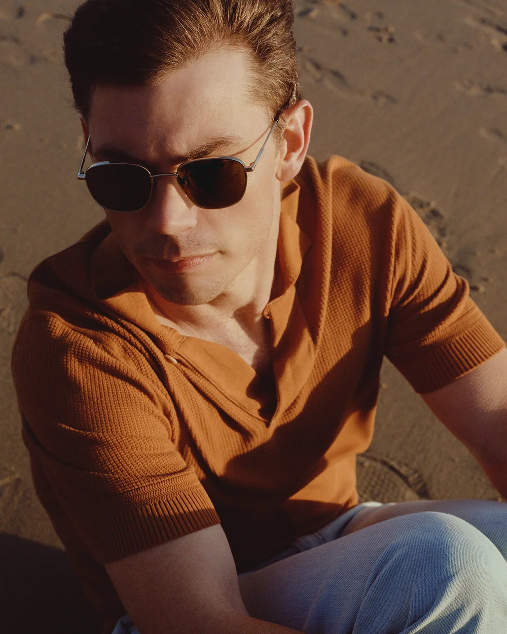 Tom Ford short-sleeve knit polo shirt, Acne Studios light blue denim jeans, Gucci belt, Uniqlo white ribbed cotton socks, Nike sneakers, RAEN sunglasses.