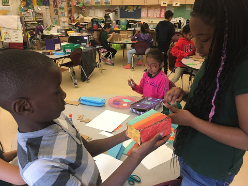学生们合作，互相帮助纸板结构.