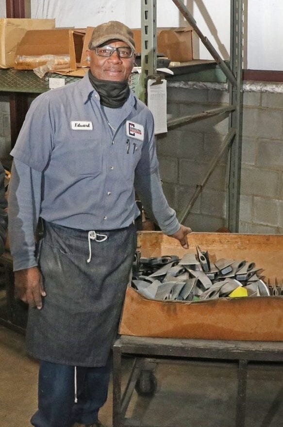 理事会工具公司的爱德华·威廉姆森在公司的瓦卡莫湖制造厂拿着一盒飞狐短柄斧头摆姿势.