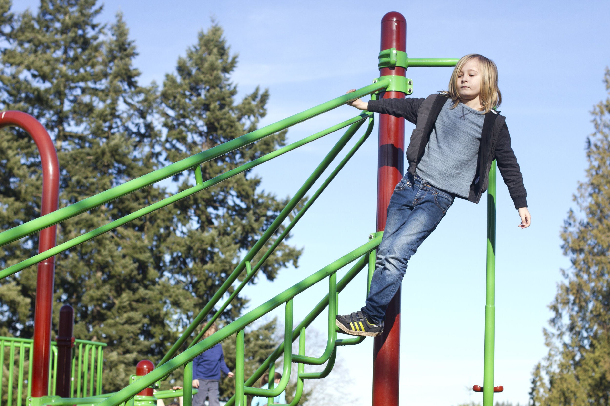 Student climbing on a tall climbing structure at a nearby park.
