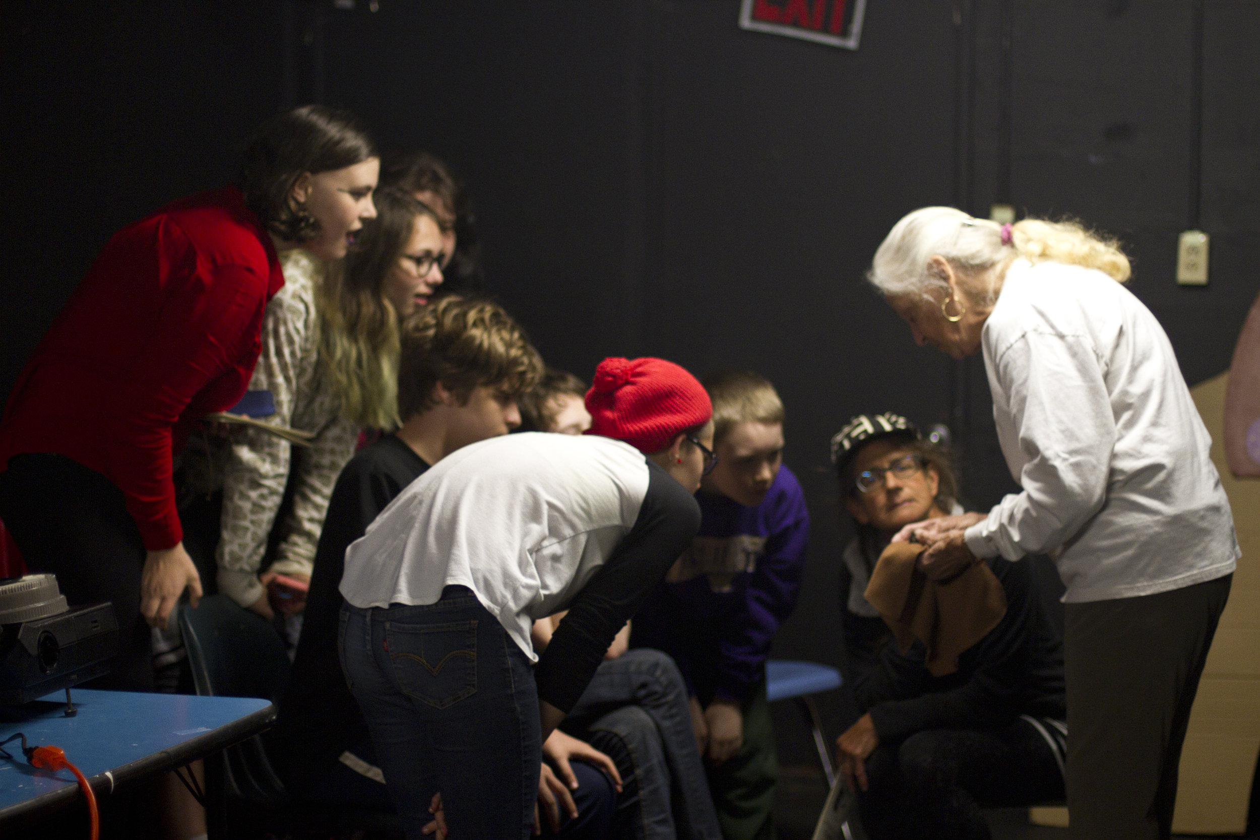 一群学生聚集在一个老人周围，在一个大发体育在线蝙蝠的演讲中，老人正在展示他们手中的东西.