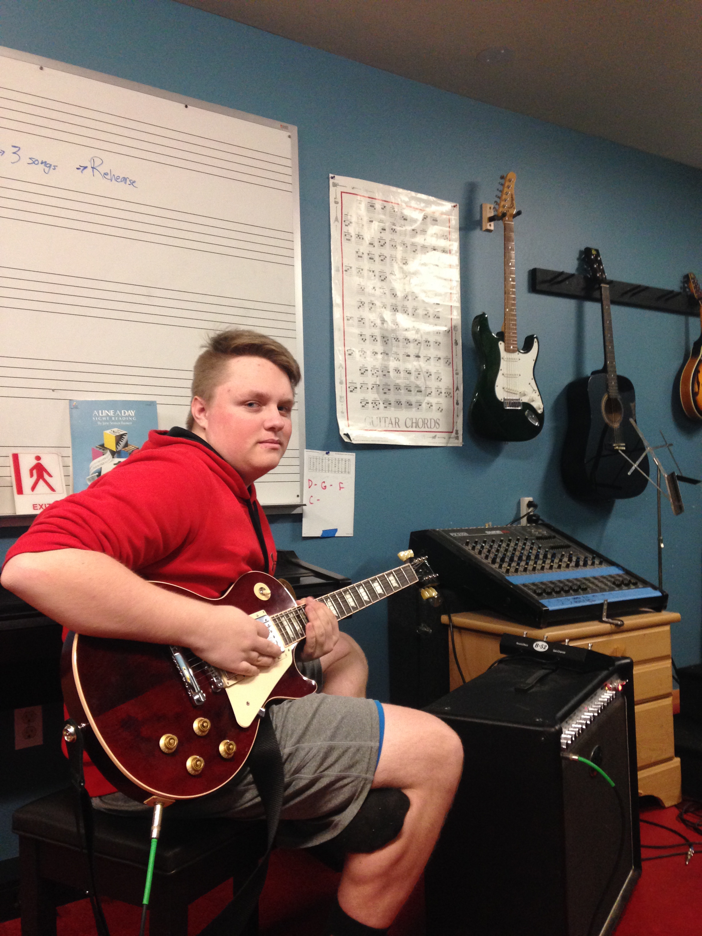 Student playing a guitar in the Music Room.