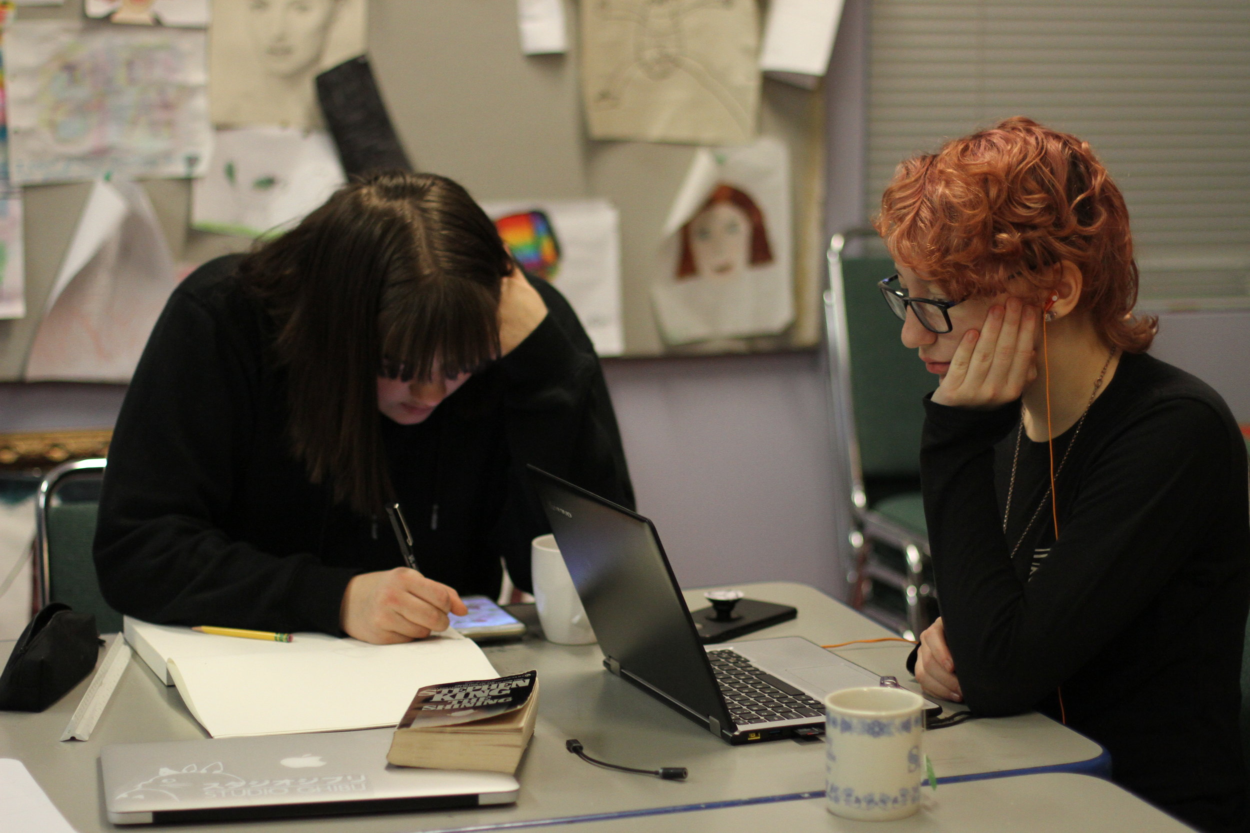 两个学生在美术室画画和学习.