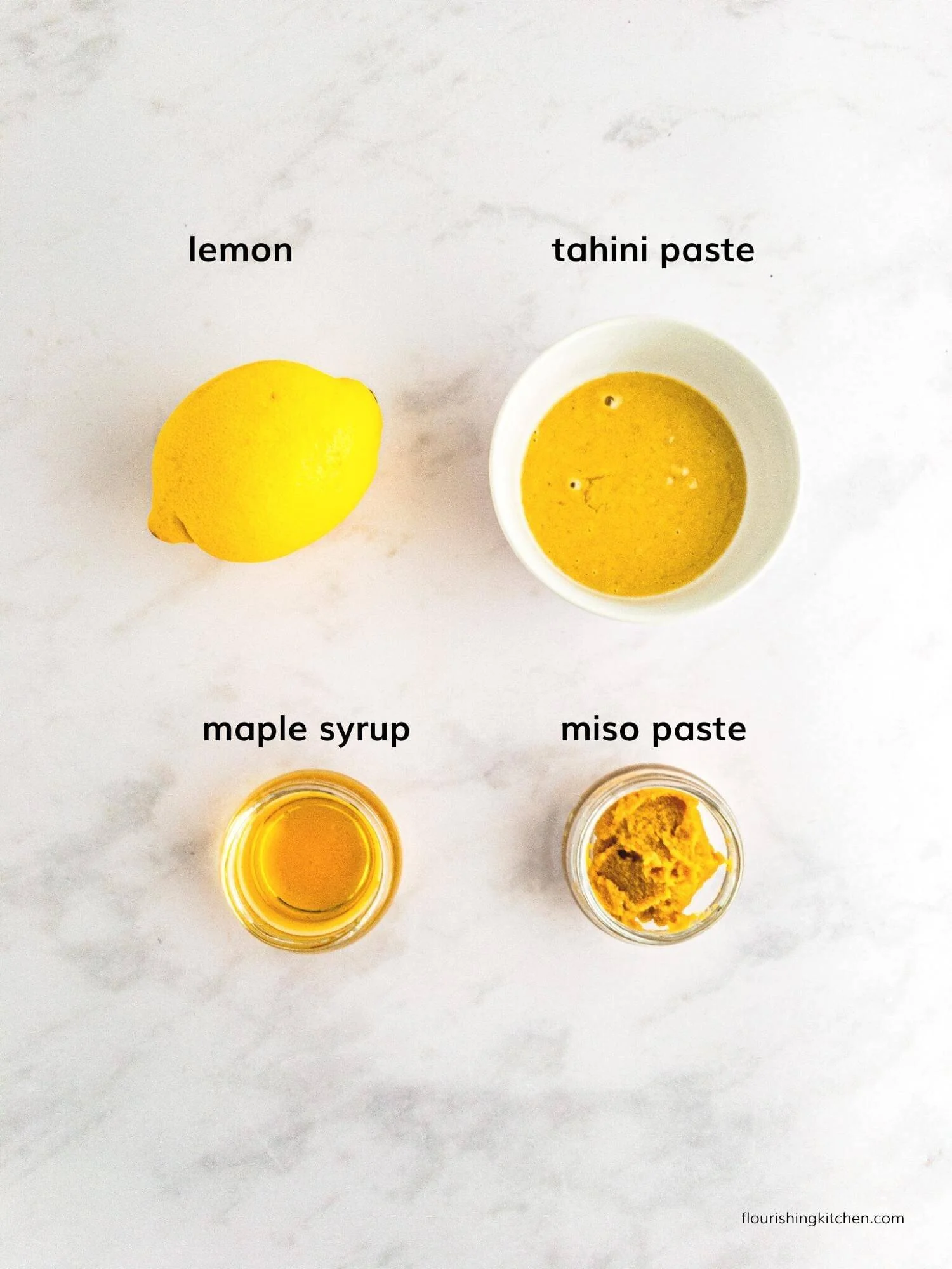 Tahini Miso敷料配方成分在轻质大理石表面上铺铺设,并单独标记。
