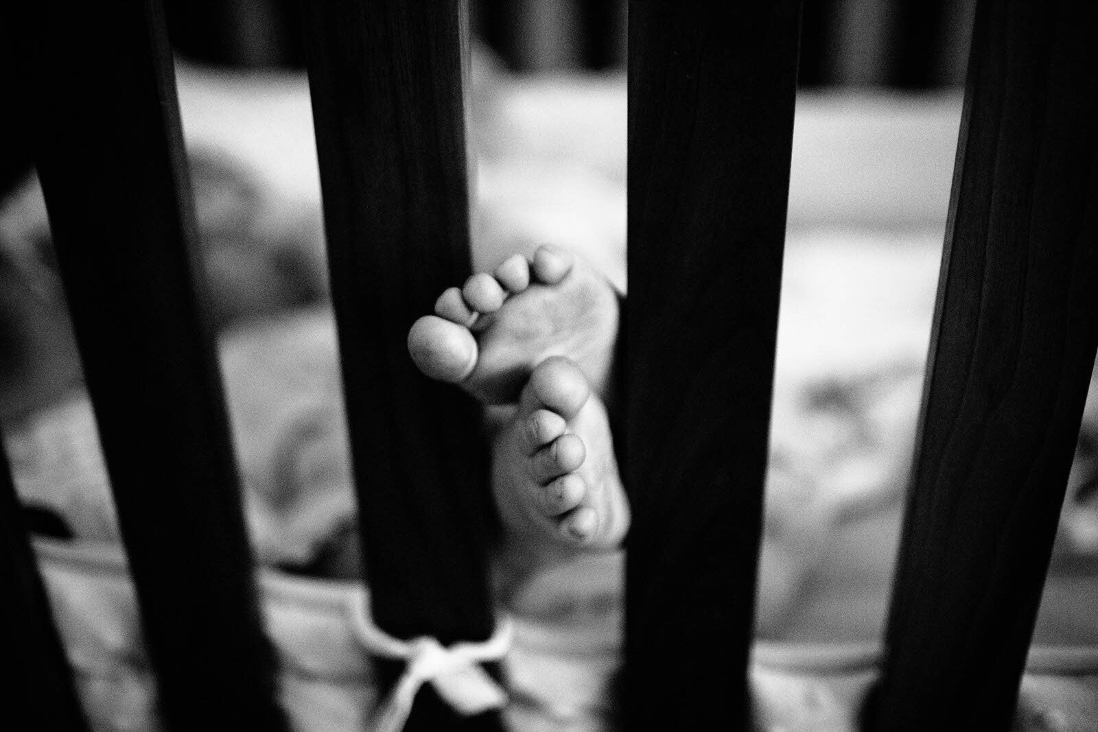 Canon EOS 5D Mark III, 35mm, 1/100 sec @ f/1.4, ISO 6400 Above: The crib slats draw the eye right to the little toes, but we’re also left wondering about who’s behind the toes, the one we can’t see due to the framing device.