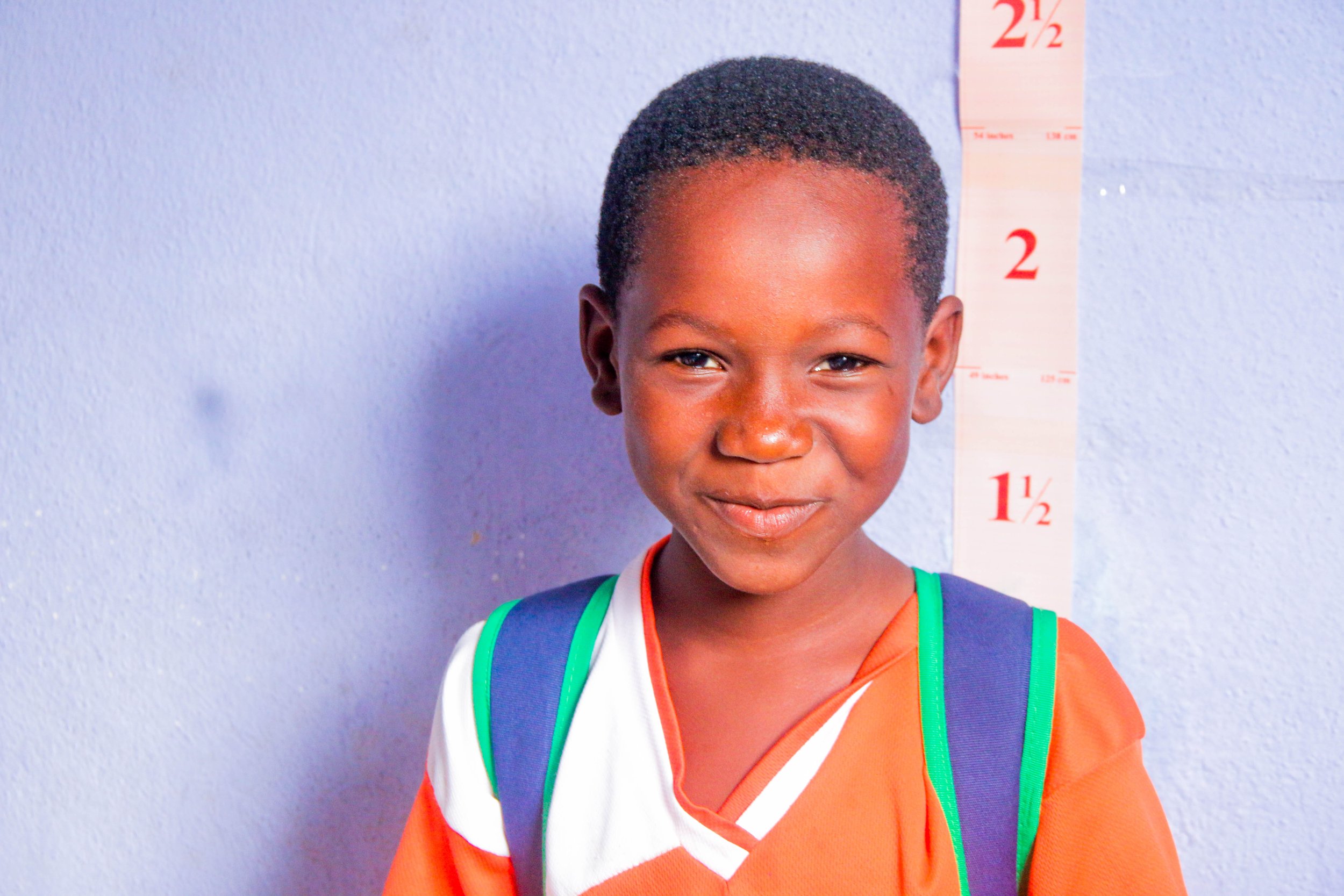 一个小女孩在学校的集体药物管理中接受预防性治疗后微笑.