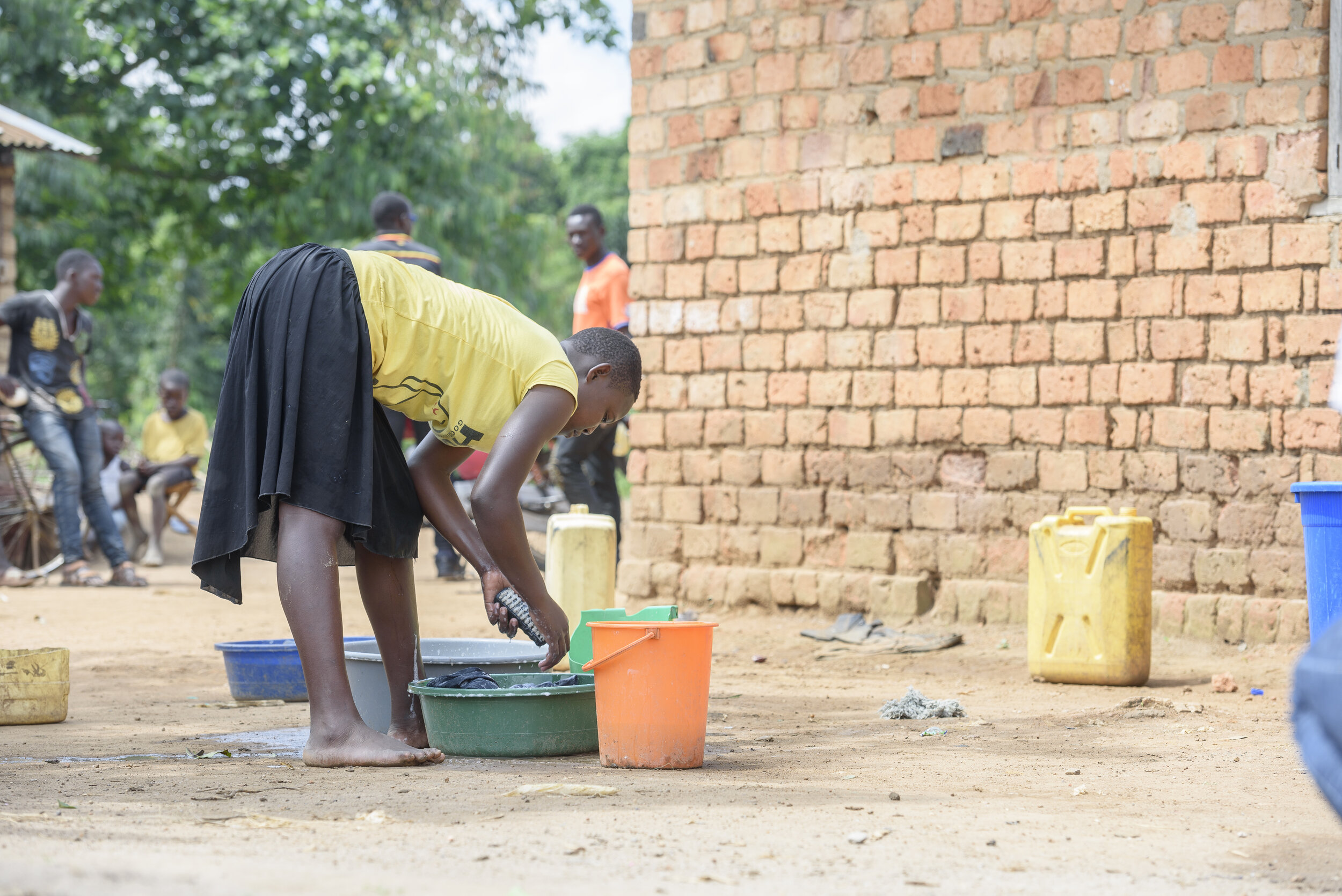 女人在桶里洗衣服. 科学基金会/乌干达