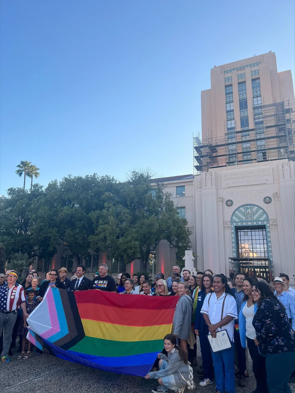a group pose with a rainbow flag