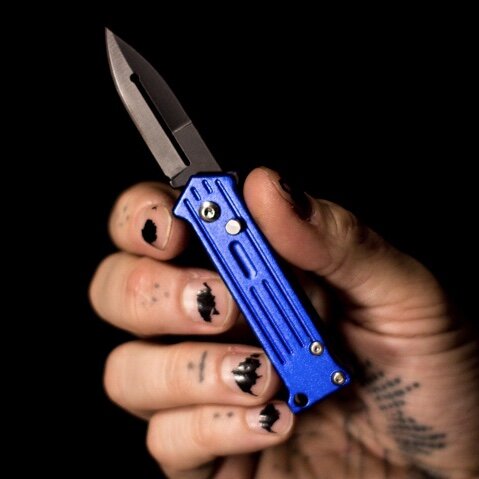 Switchblade knife on old blue jeans- CanStock