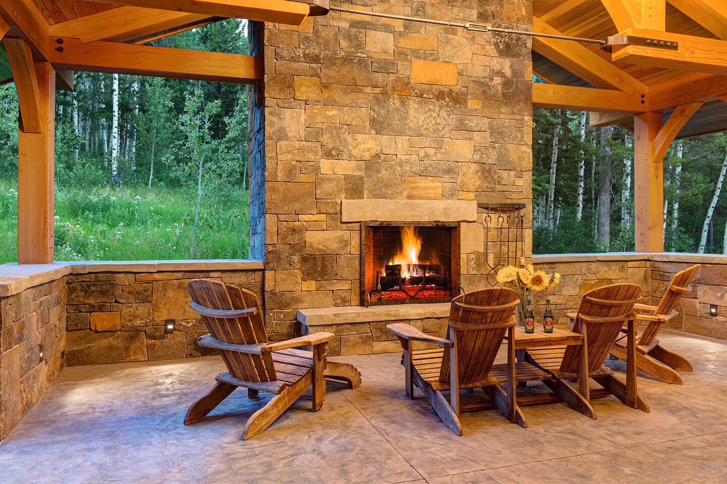 Outdoors stone fireplace with Adirondack chairs