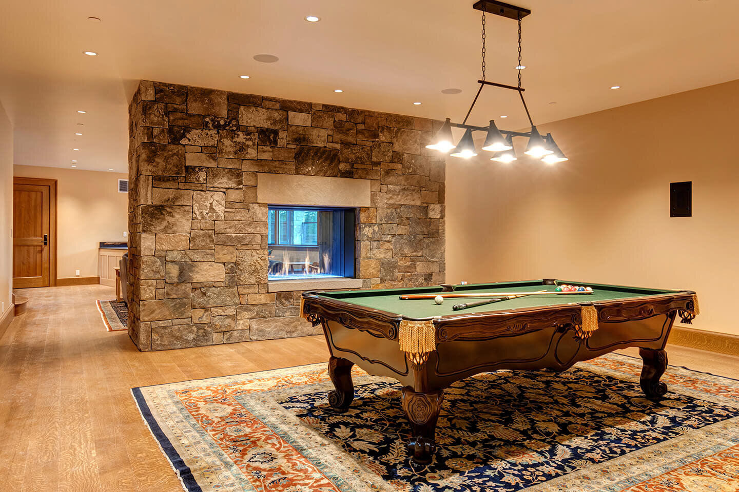 Billiards room with center stone fireplace