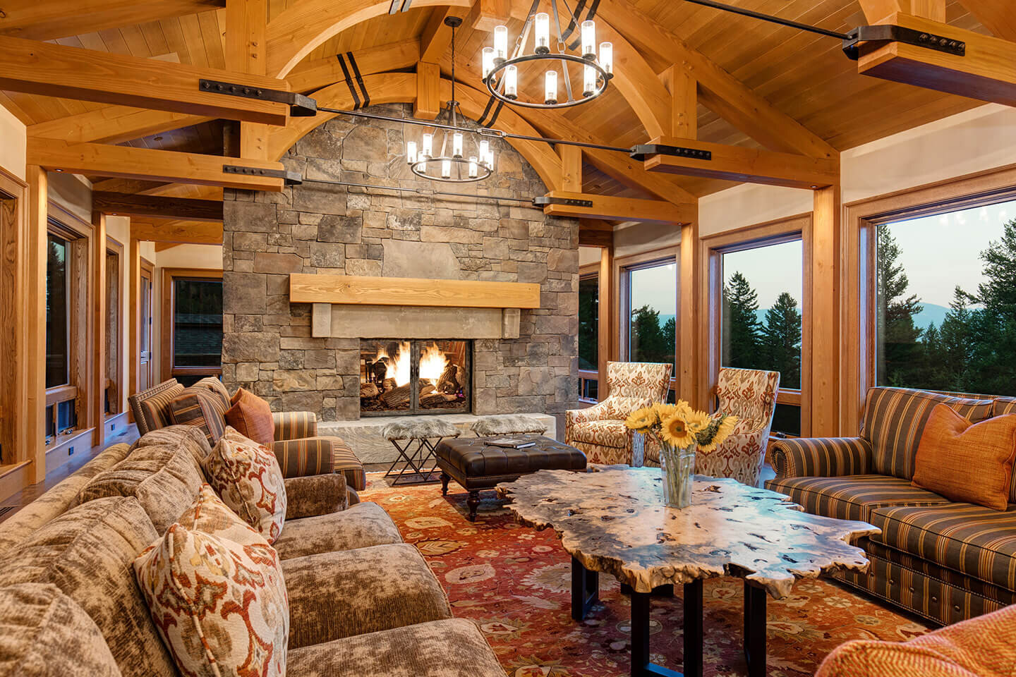 Living room with stone fireplace and arched trusses