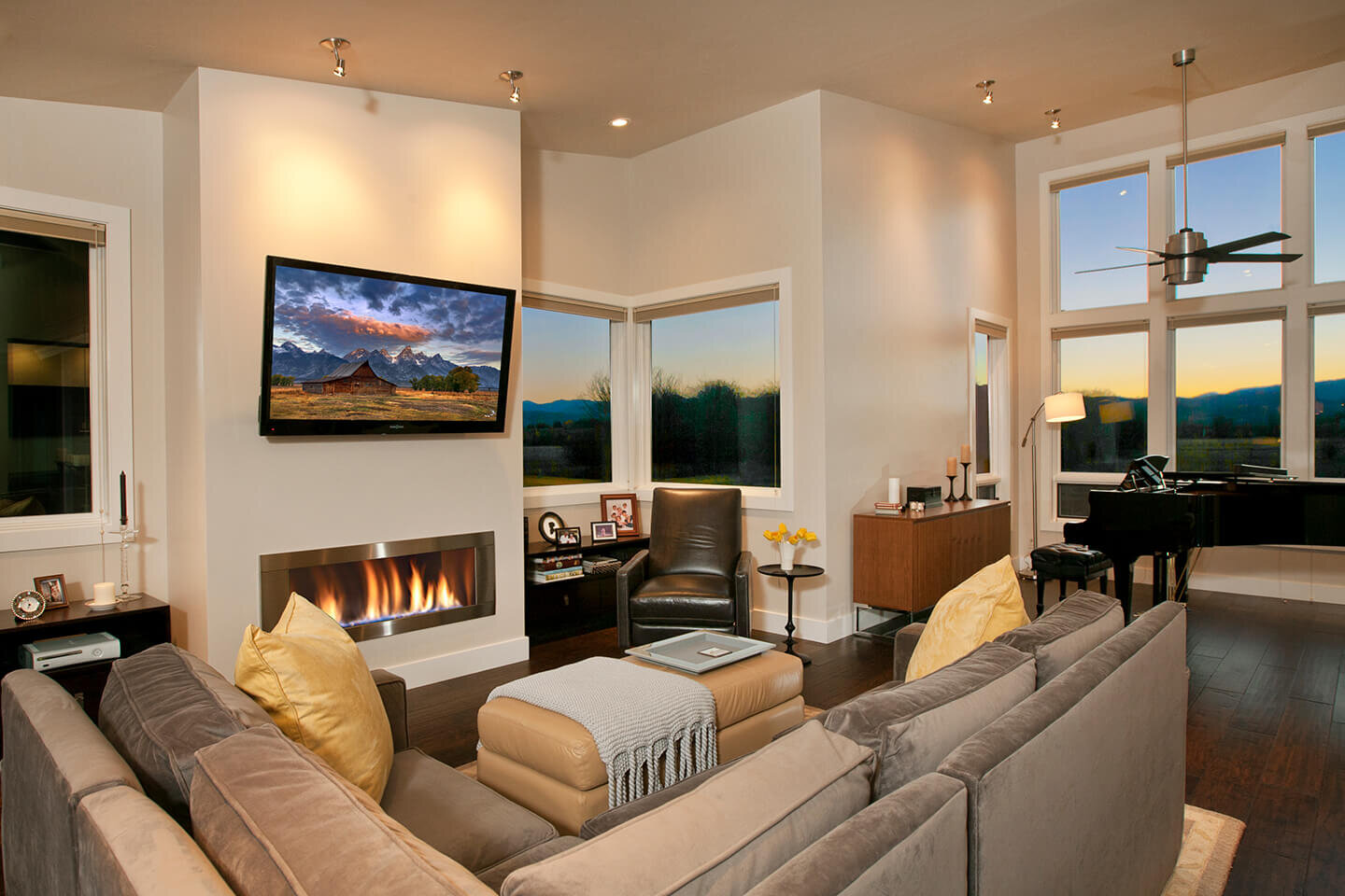 Living room with lit up gas fireplace and large windows