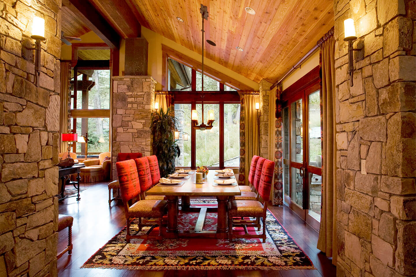 Dining room with red chairs and native stone walls