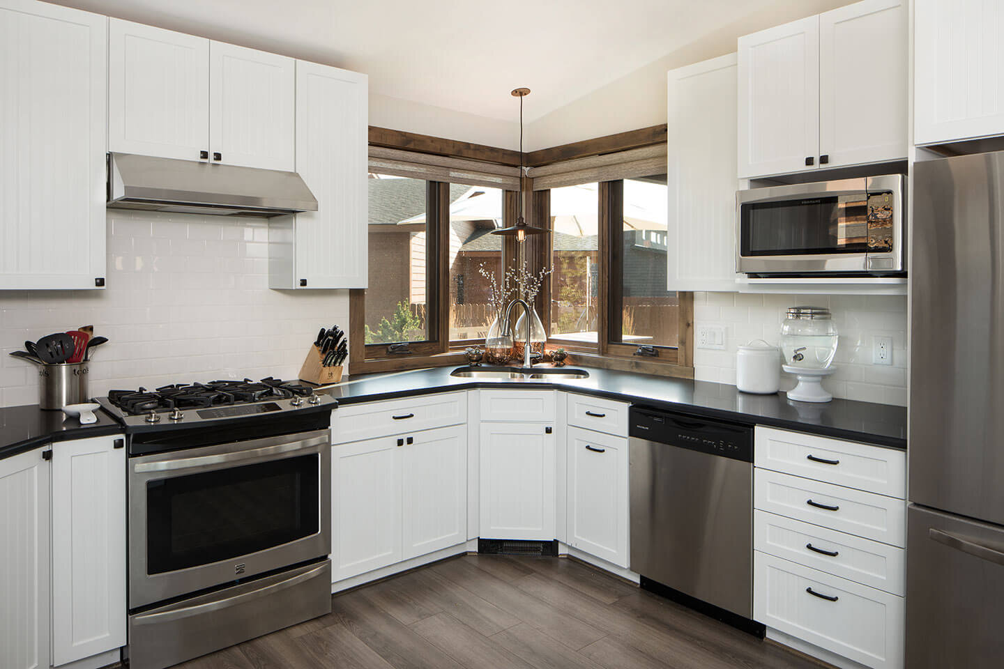 Kitchen with white cabinetry and corner windows