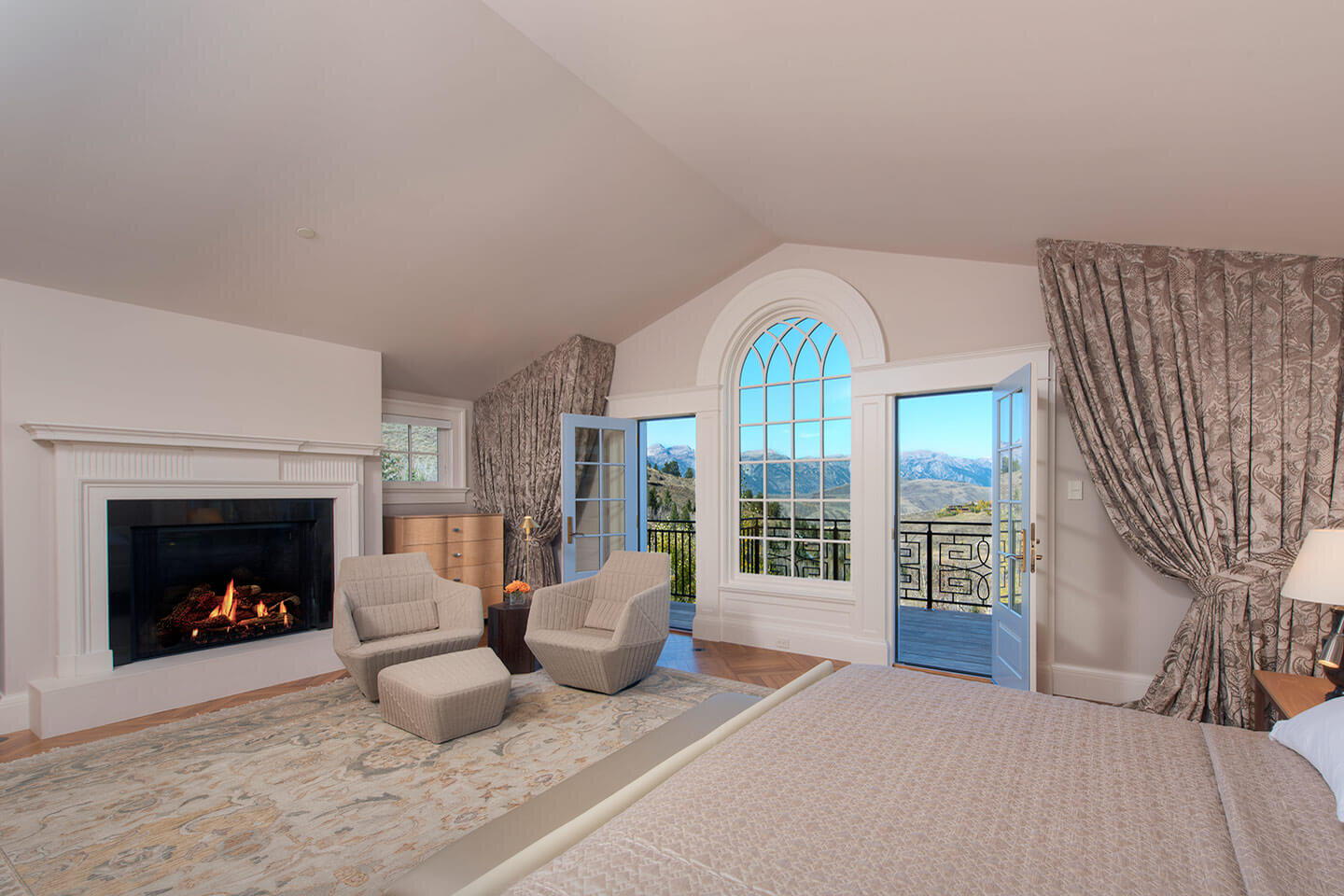 Master bedroom with arched window and fireplace