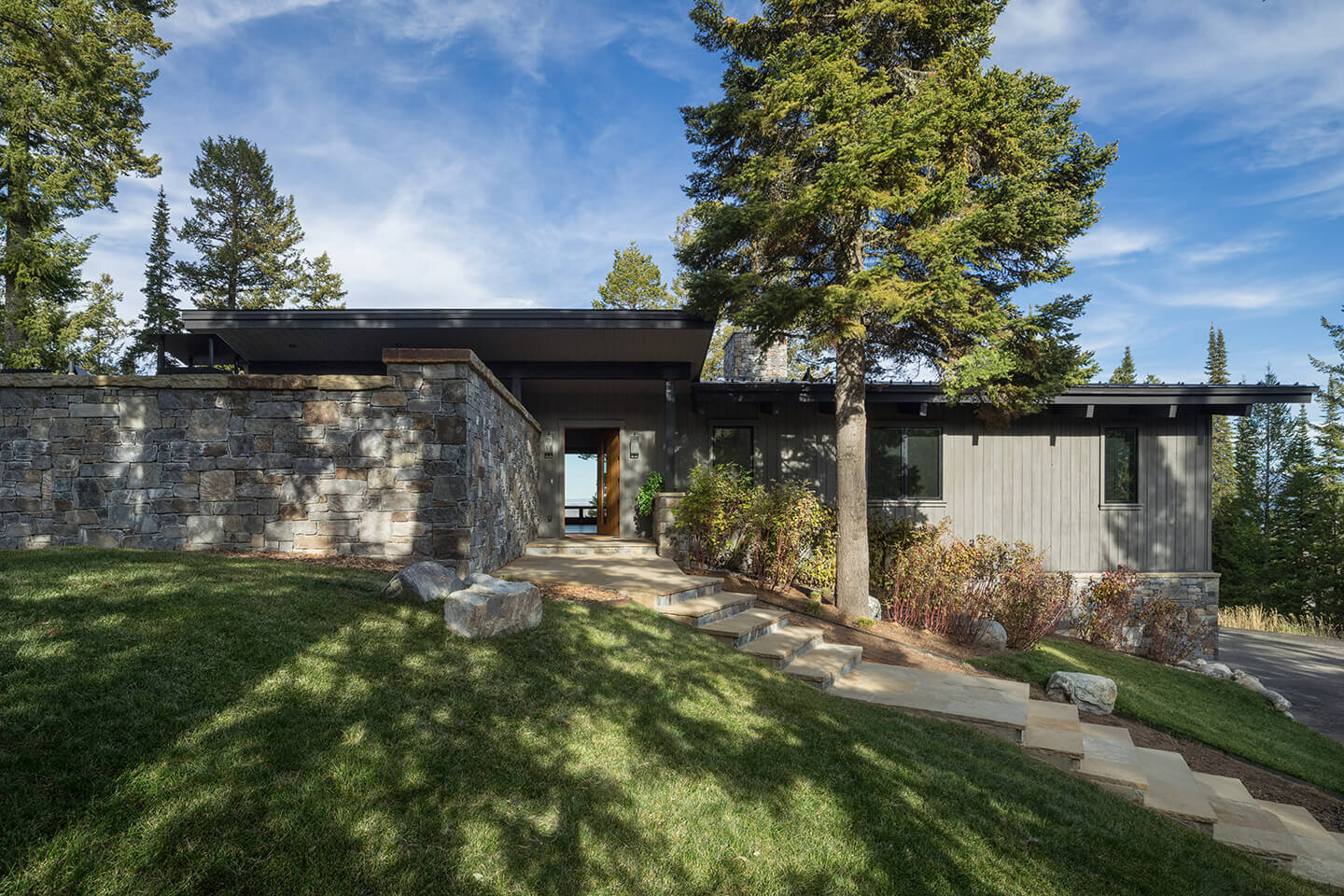 Home exterior with native stone wall and staircase