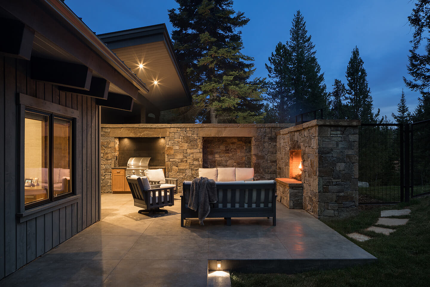 Patio at twilight with fireplace and butterfly roof