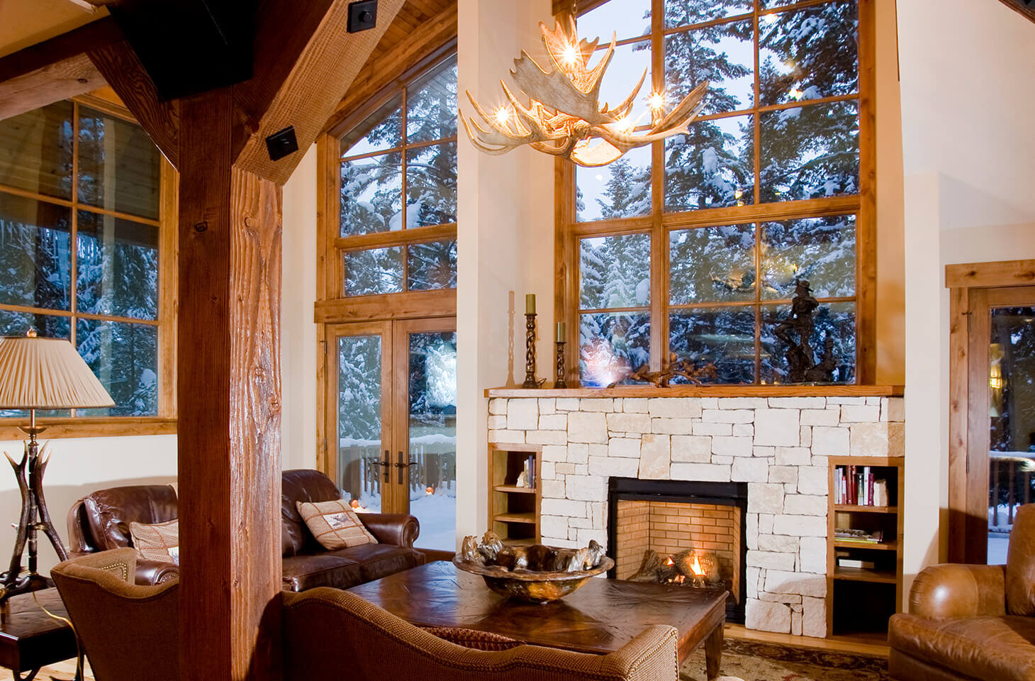 Living room with antler chandelier and open hearth fireplace