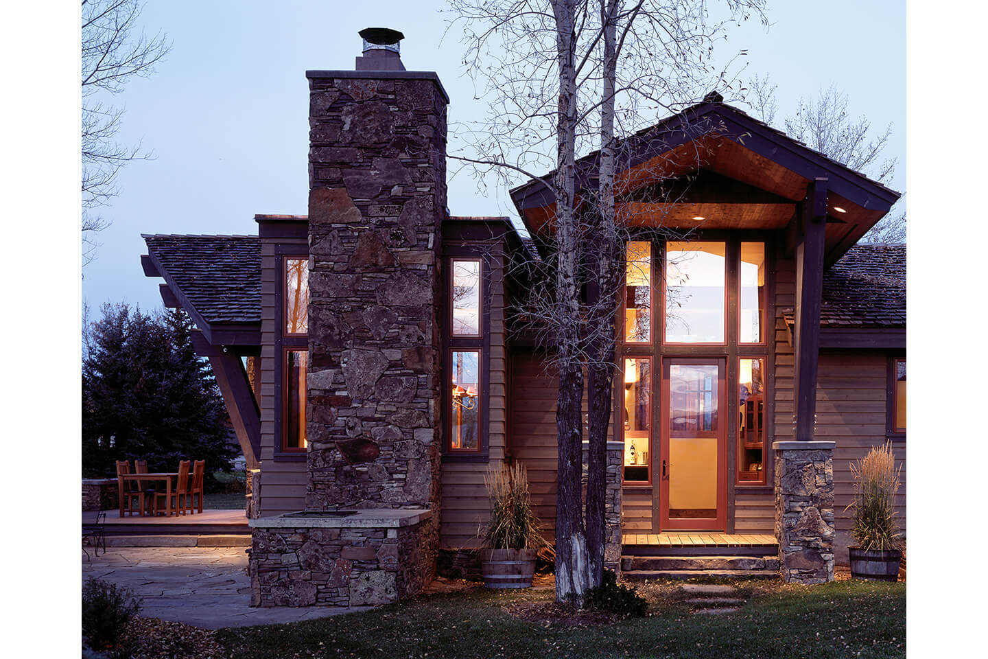 Twilight view of residence with chimney