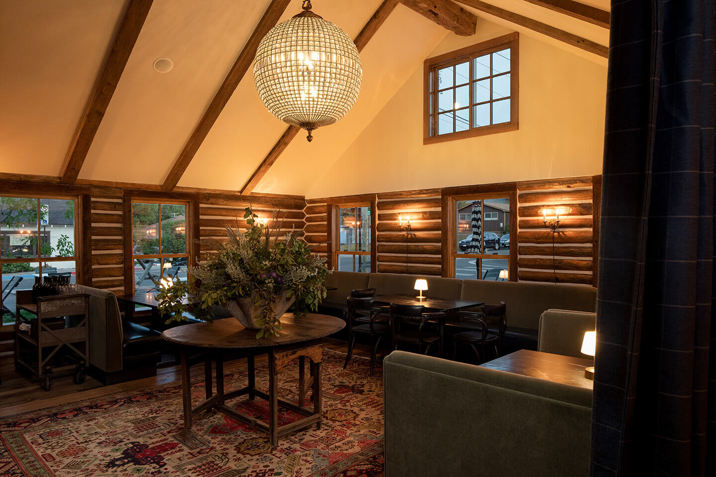 Restaurant dining room with beams and logs and a disco ball