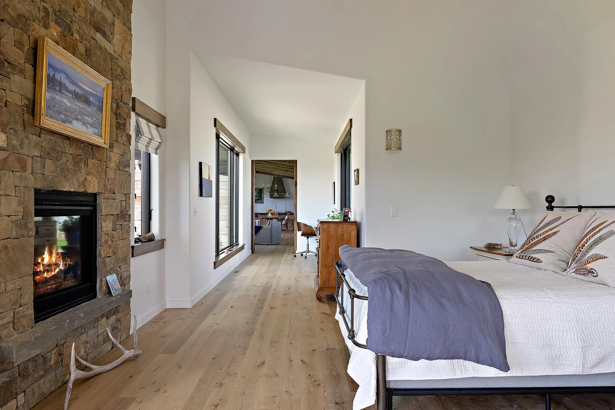 Master bedroom with white walls and stone fireplace