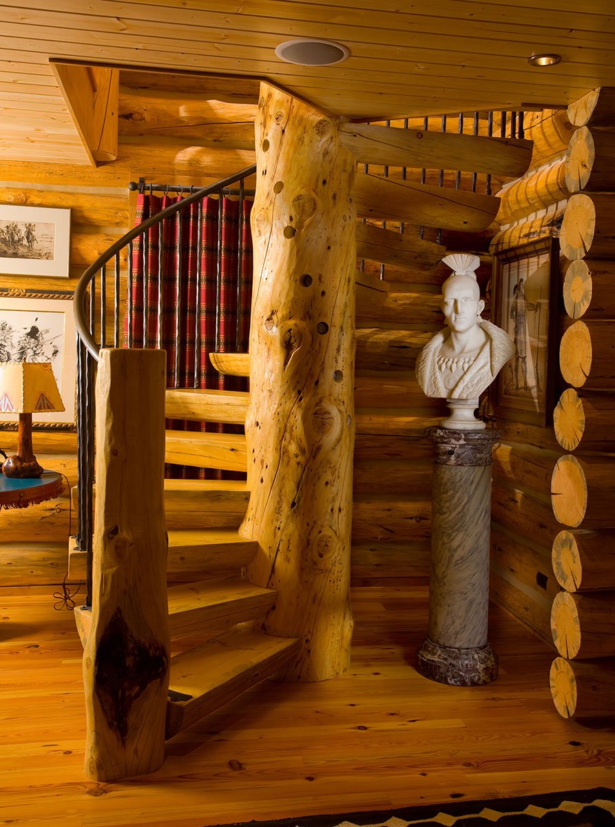 Spiral staircase in log home with large column