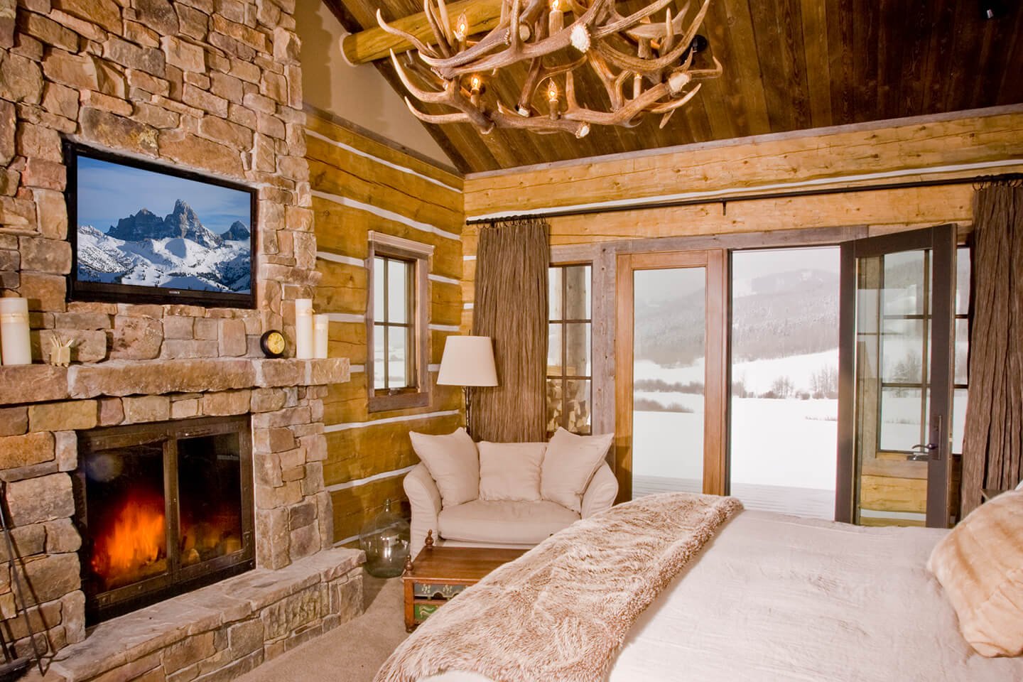 Master bedroom with fireplace and antler chandelier