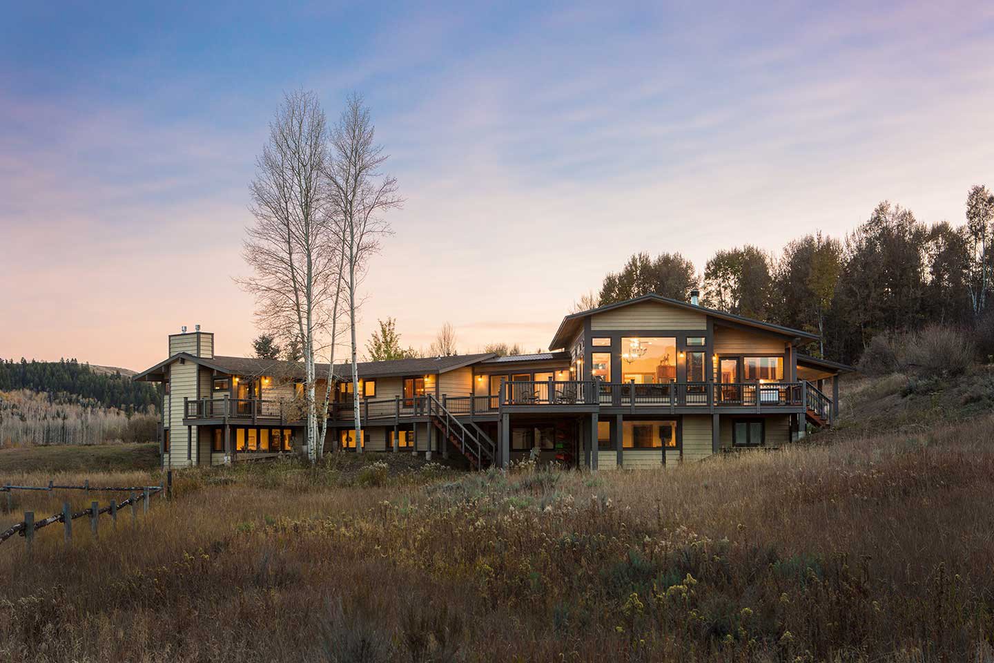 Residence at twilight with tall aspen trees