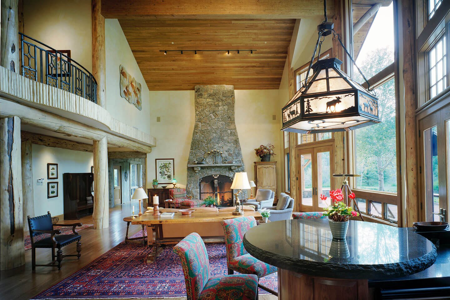 Living room with native stone fireplace and dining room with chandelier