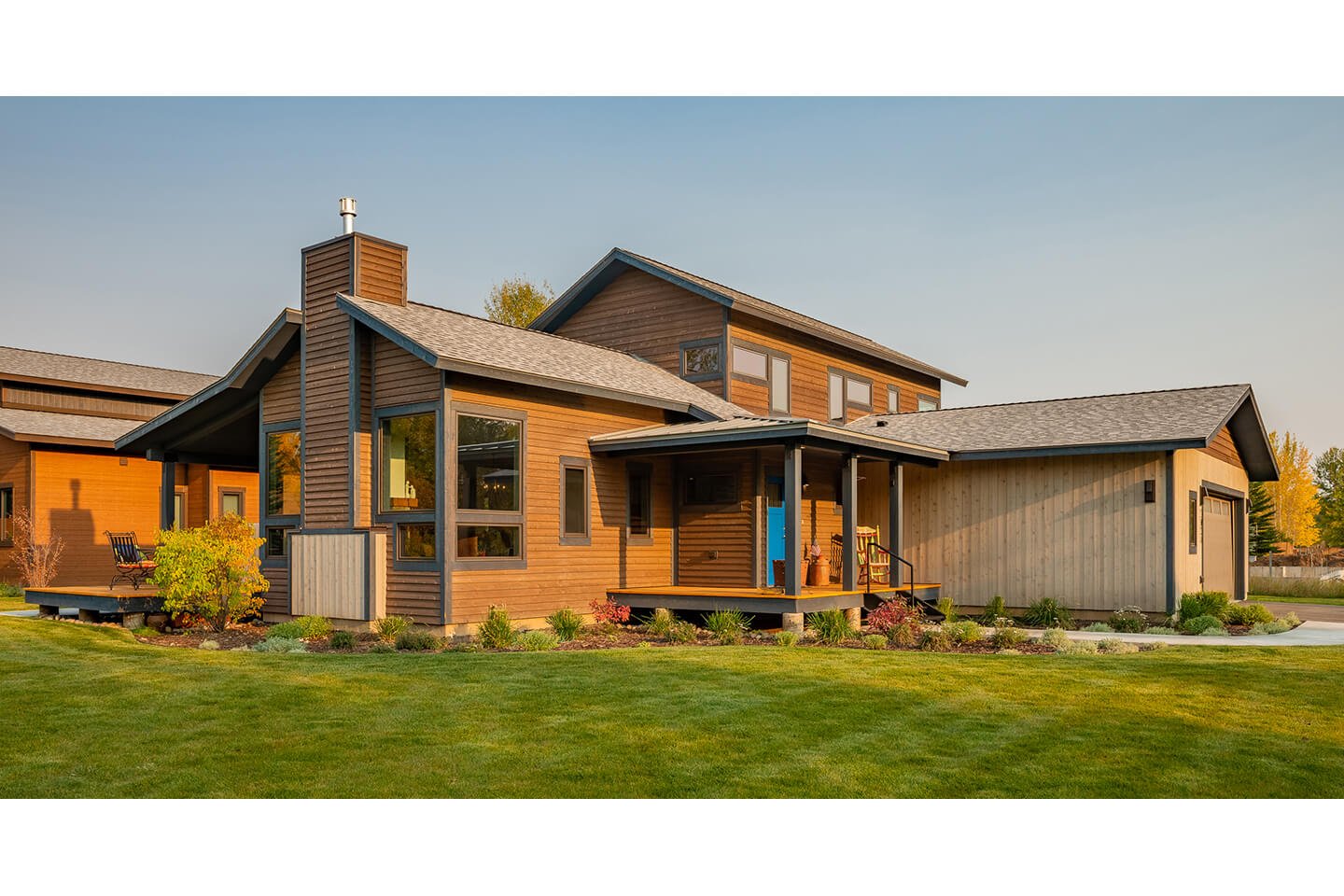 House with earthy tones siding and blue entry door