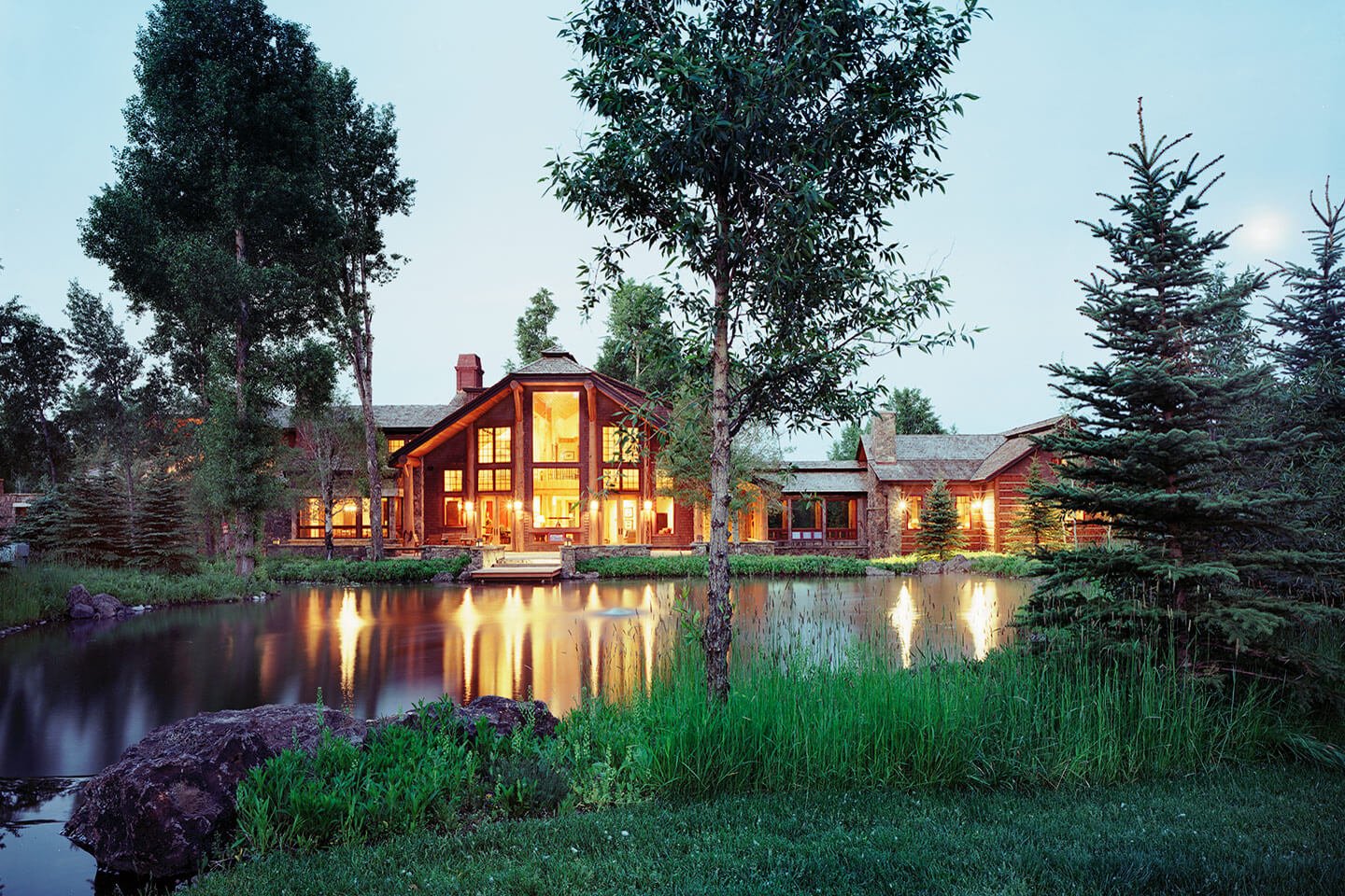 Log home at twilight with reflections in the water