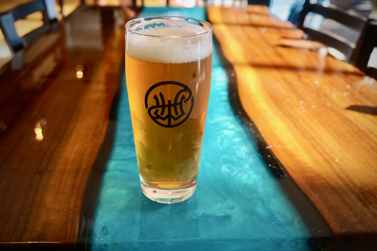 新的 Working Hands Beer 酒吧里的环氧树脂活边胡桃木桌