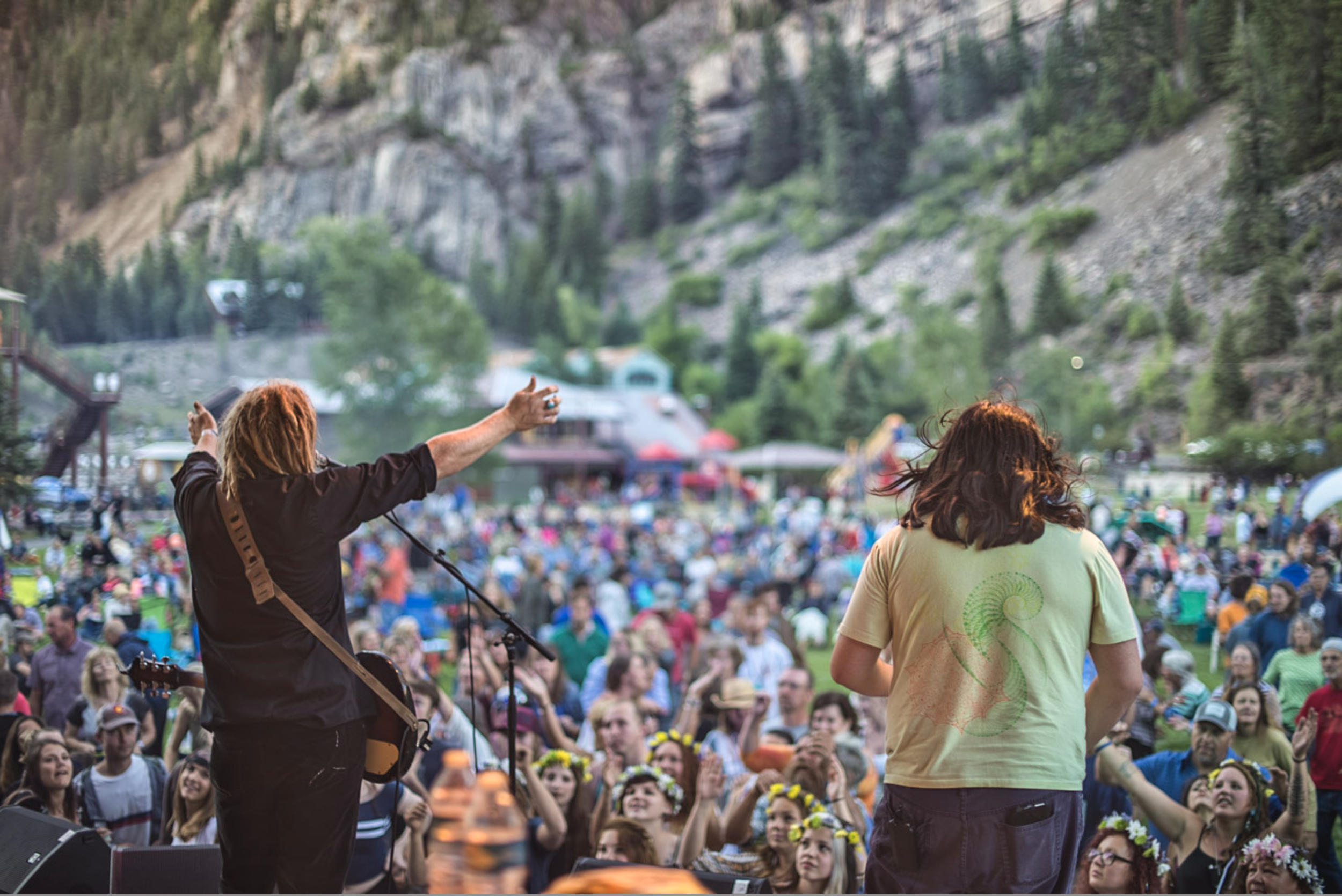 Two musicians on stage with crowd in background