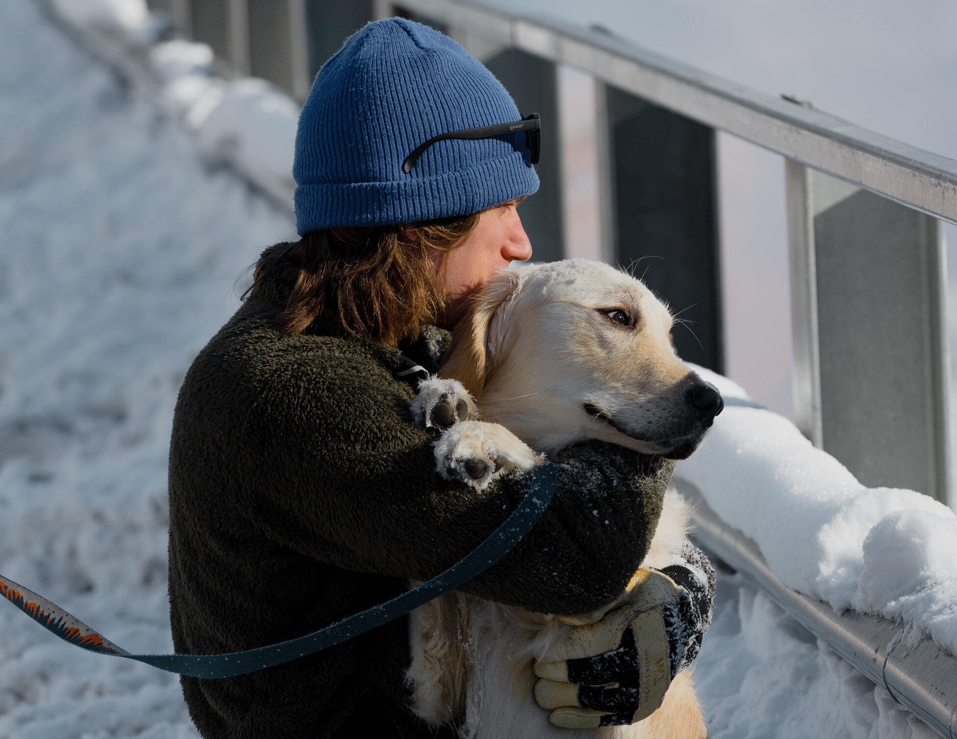 Girl hugging white dog in snow