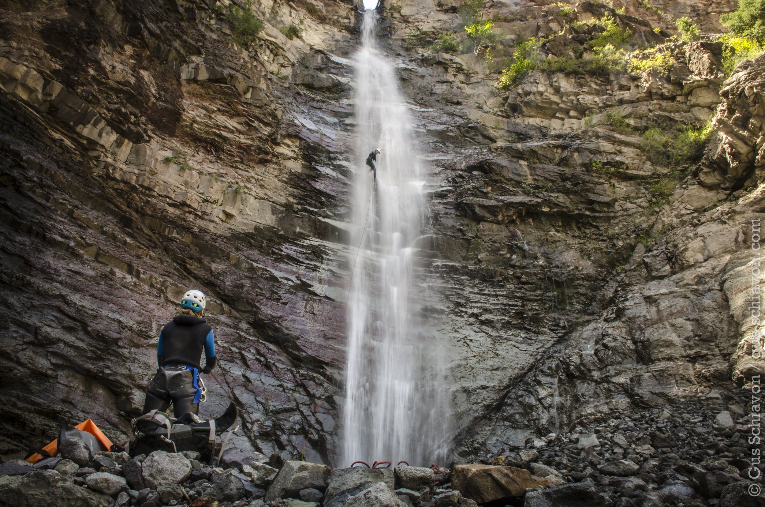Man standing at bottom of waterfall