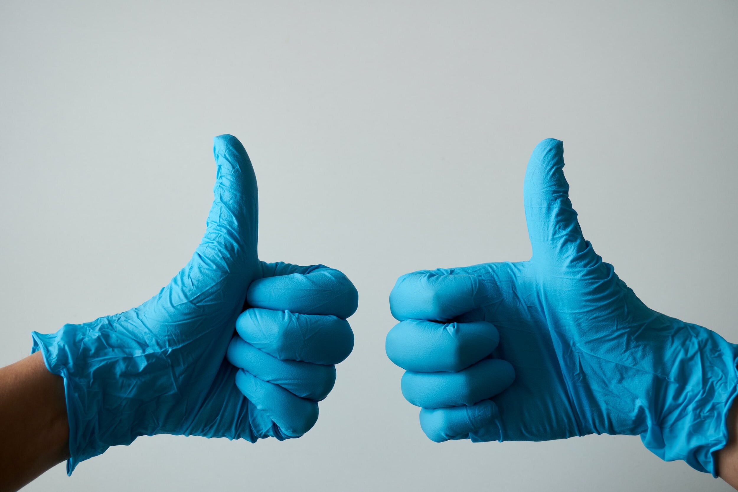 Two thumbs up in blue gloves