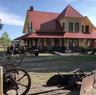 Old building with farming equipment in foreground