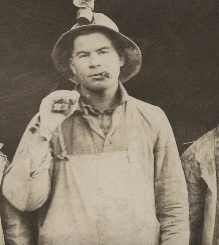 Man smoking cigar in old mining helmet