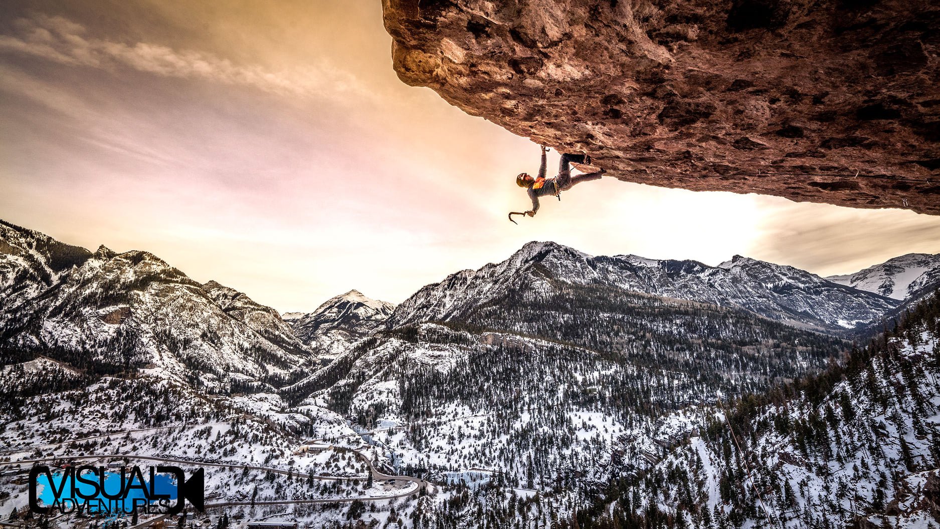 Guy ice climbing on overhang rock