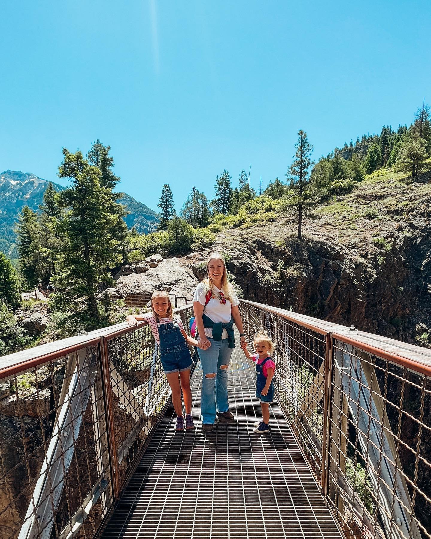 Mom with two daughters on a bridge