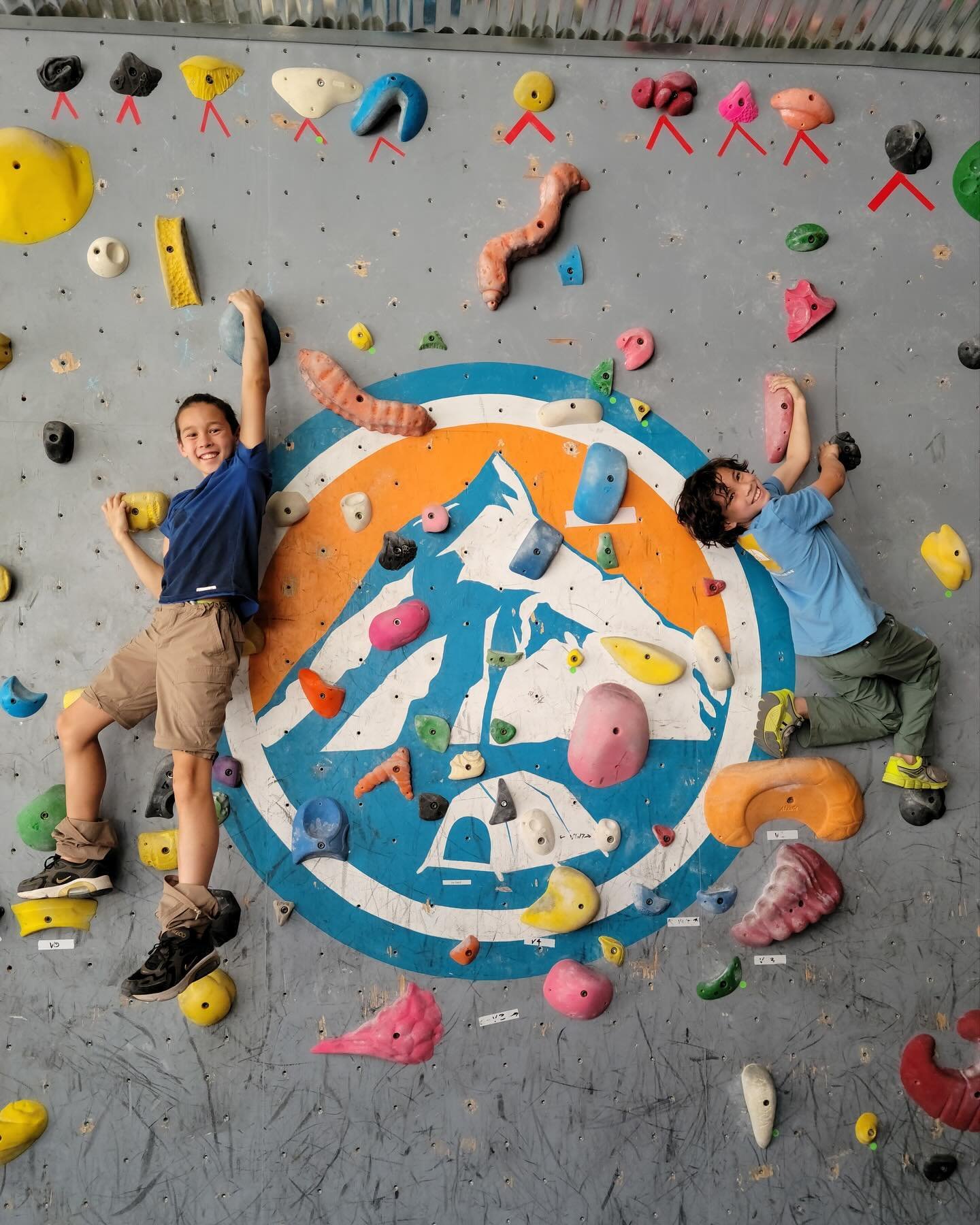 Two kids climbing on wall