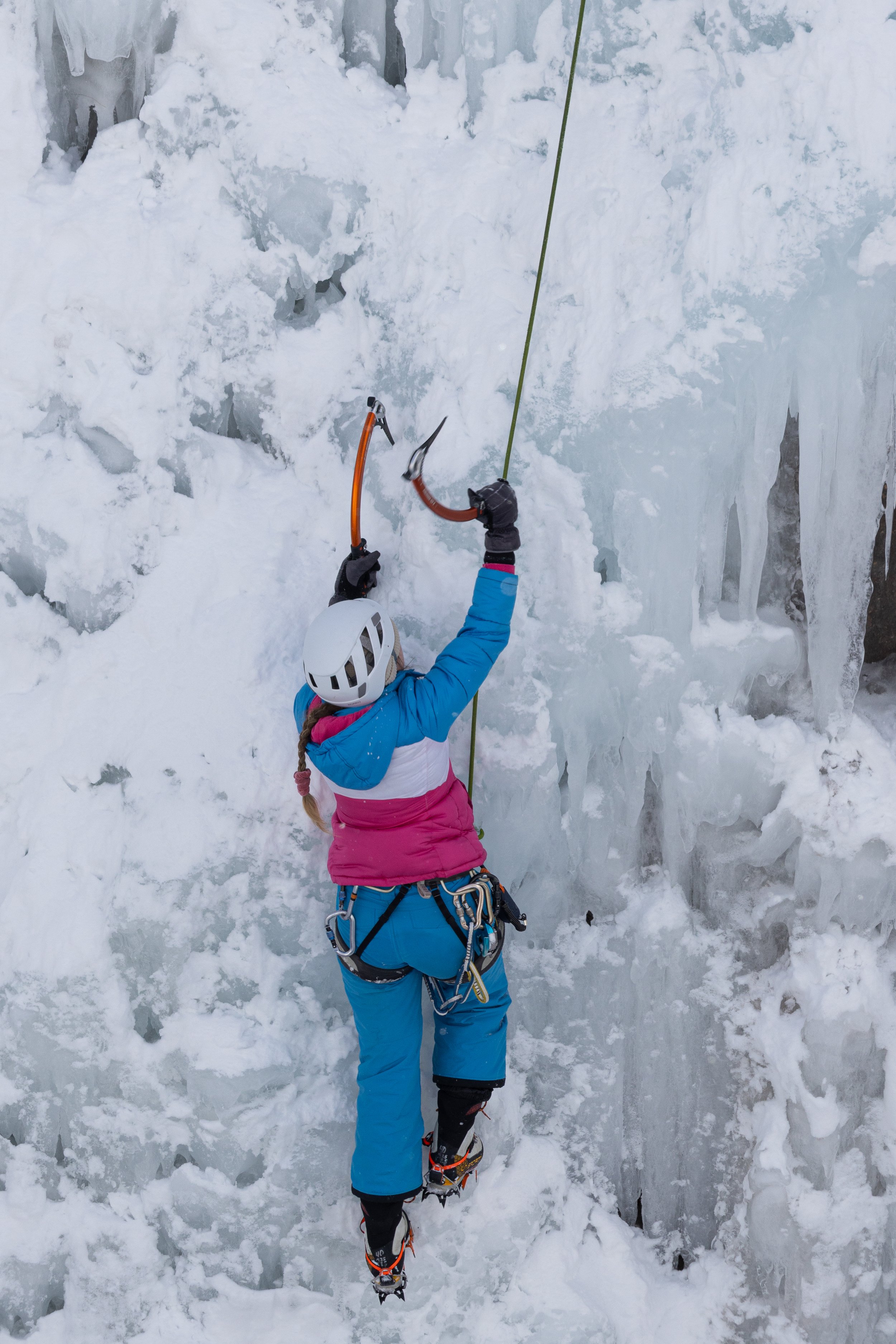 Girl climbing up ice wall