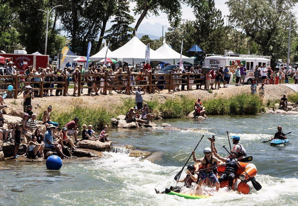 People on river shore watching rafters go by