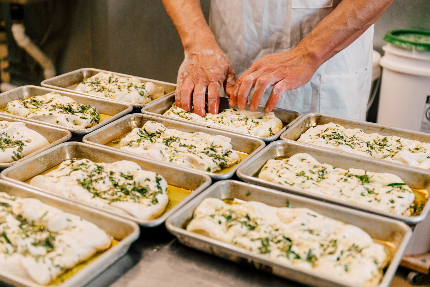 面包师在斯卡吉特山谷食品皇冠博彩面包店制作新鲜的佛卡夏面包