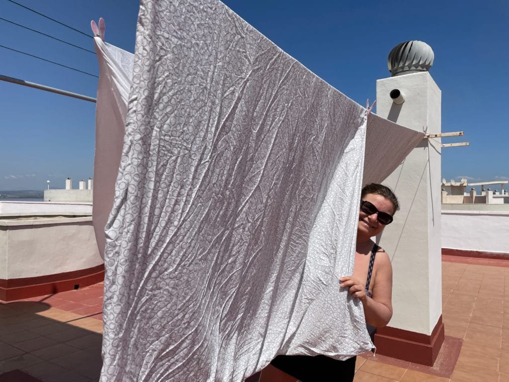 Kvinna hänger upp tvätt på taket i Torrevieja.