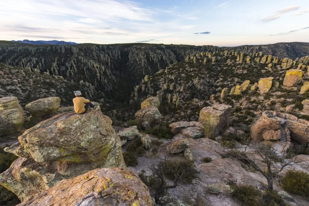 Man sitting on a rock ledge in the Chiricahua National Monument