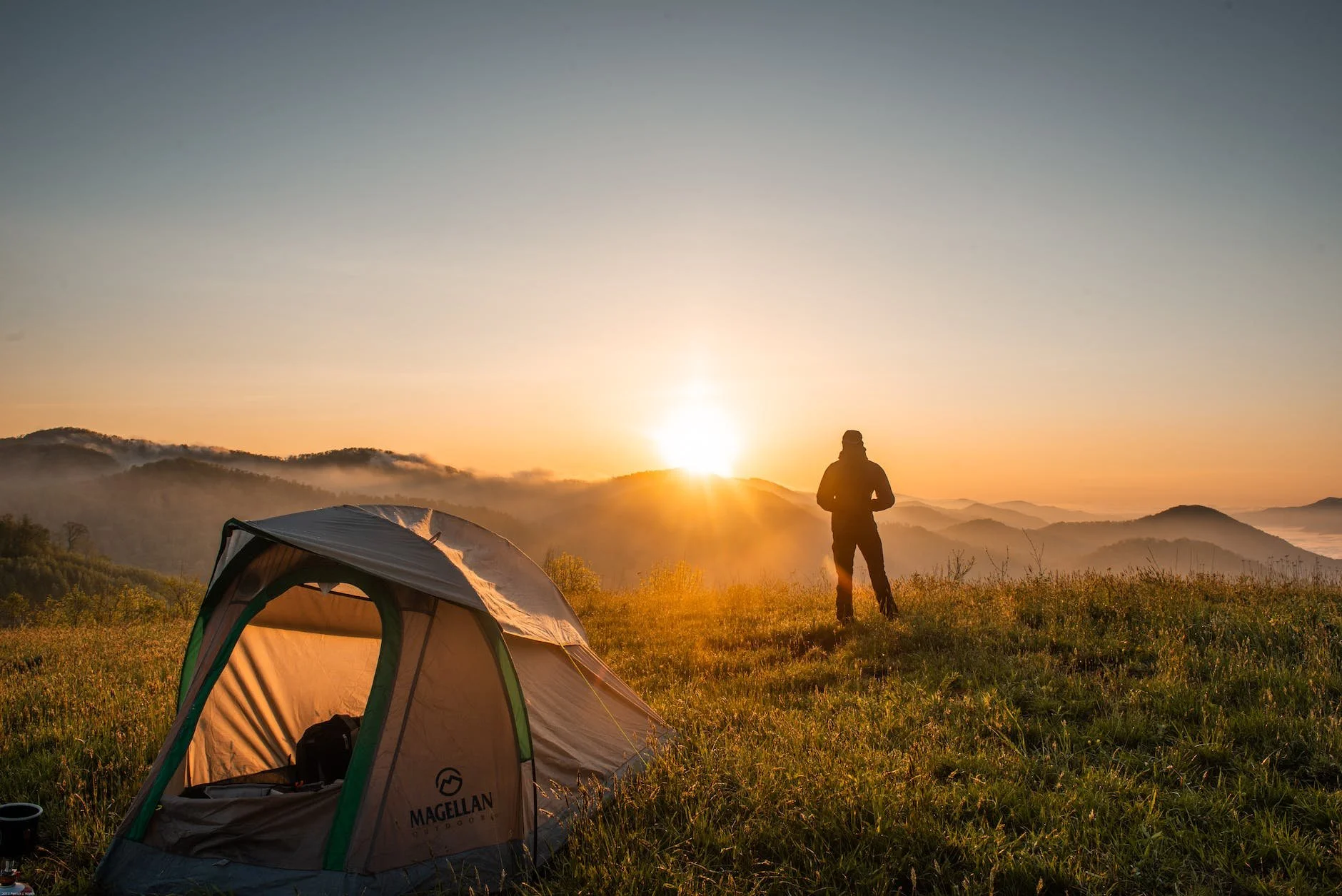 silhouette of person standing near car camping tent